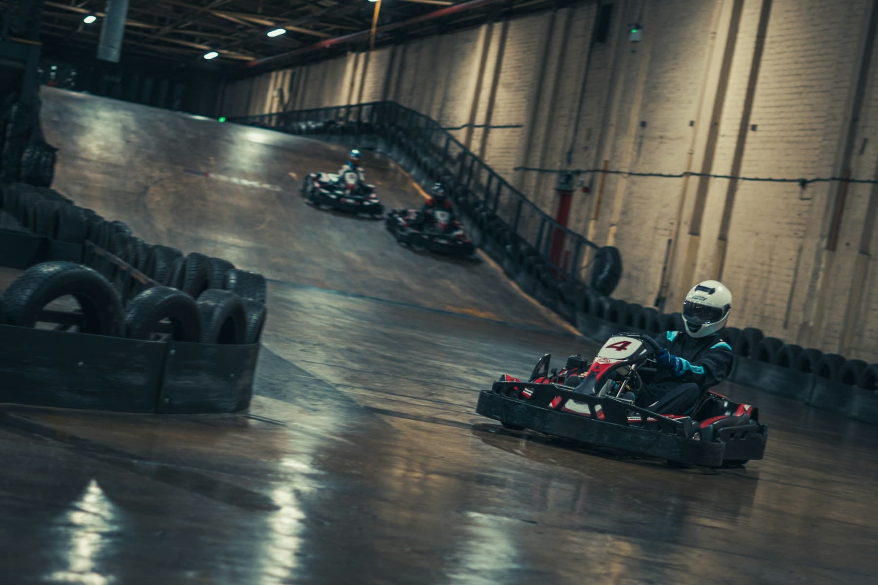 Drivers competing on an indoor karting circuit